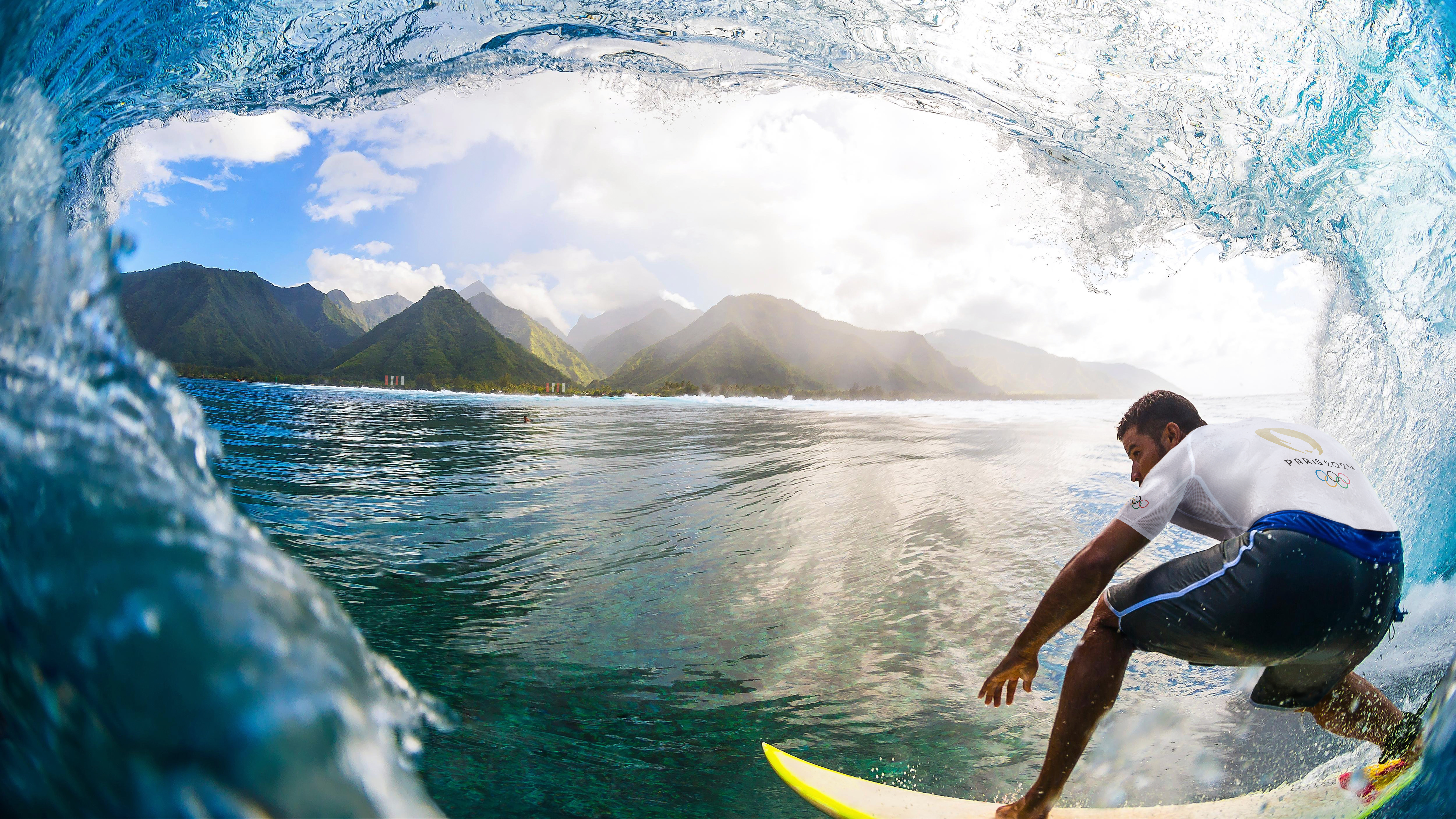 Athlète qui surf une vague à Tahiti