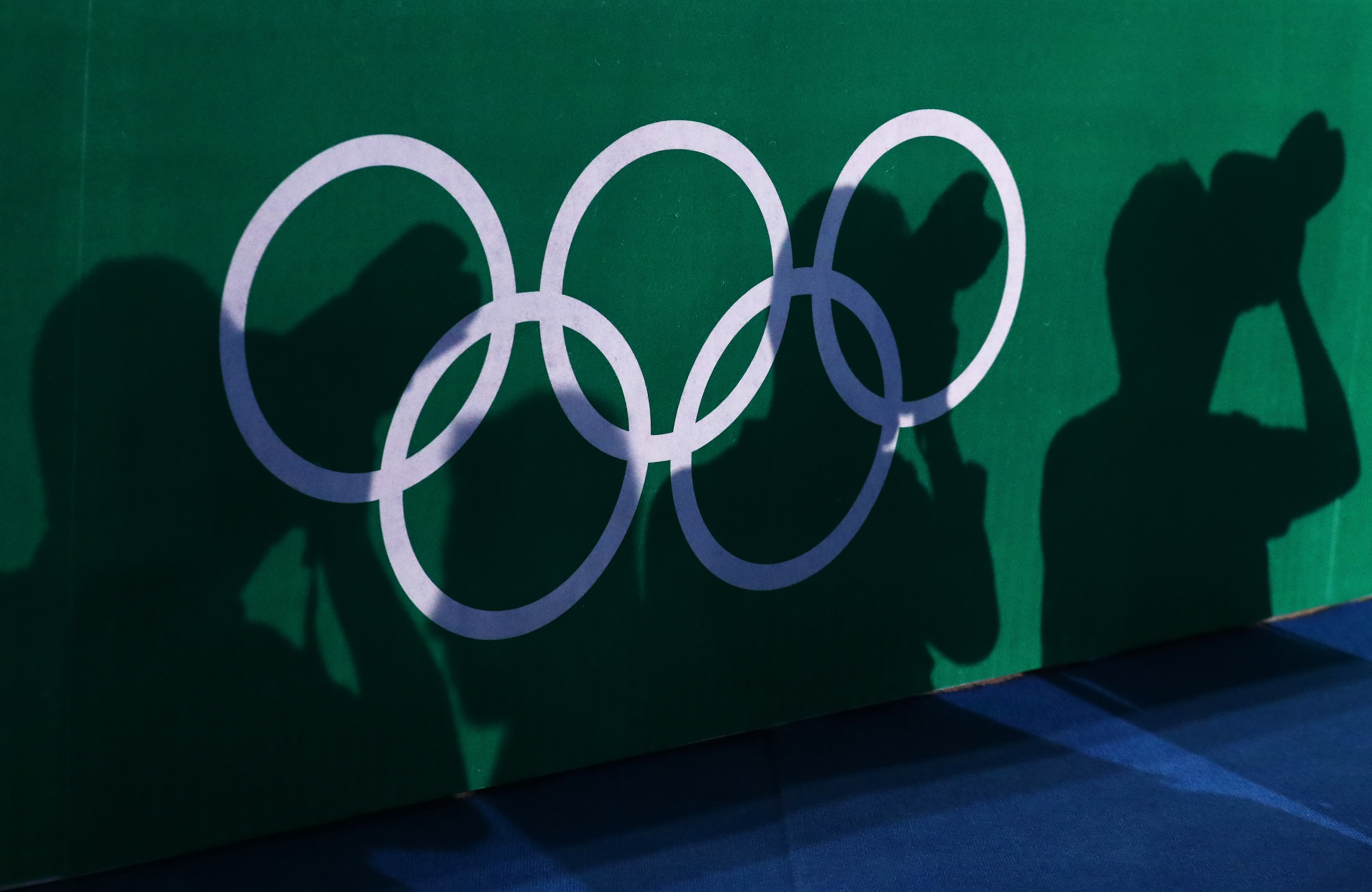 Ombre de plusieurs photographes sur les anneaux olympiques